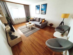 a living room with a couch and two chairs at SeaLover Apartment in Constanţa