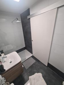 baño con lavabo y puerta blanca en Apartment am Eiskanal, en Augsburg