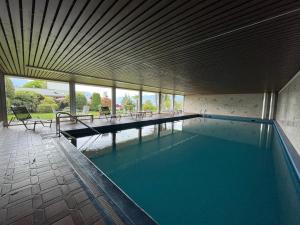 a swimming pool with blue water in a building at Locarno-Monti: Solemonte Apt.103 in Locarno