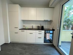 a kitchen with white cabinets and a sink at Locarno-Monti: Solemonte Apt.103 in Locarno
