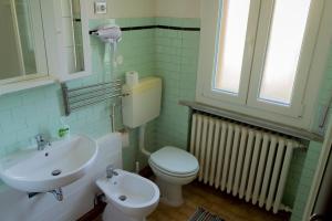 Un baño con un inodoro blanco y un lavabo. en Reno Family House, en Rávena
