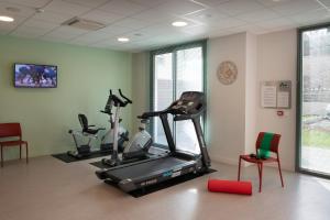 a gym with three exercise bikes in a room at DOMITYS La SARDONNE centre-ville in Le Puy en Velay