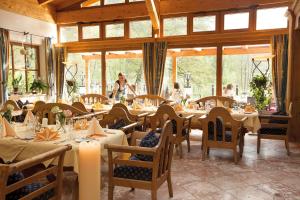 a restaurant with tables and chairs with people in the background at Huber Hotel Tramserhof in Landeck