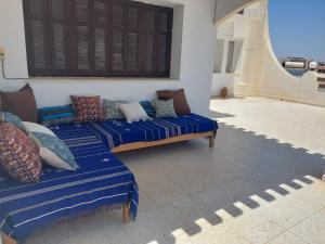 - un salon avec deux canapés et des oreillers dans l'établissement Chambre Hannon Résidence Chahrazad, à Sfax