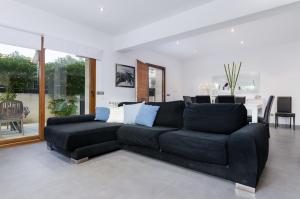 uma sala de estar com um sofá preto e uma mesa em YourHouse Es Cardinal em Can Picafort