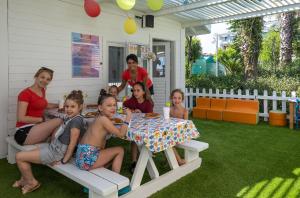 a group of children sitting at a table on a patio at Orange County Belek in Belek