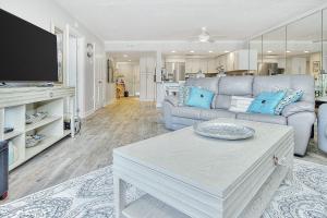 uma sala de estar com um sofá e uma mesa em Beach Cottage 1205 em Clearwater Beach