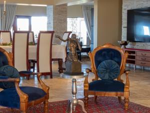 a living room with chairs and a statue and a television at Castle On The Heads in Knysna