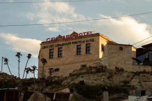 un edificio en la cima de una colina con un cartel. en Cave Art Hotel Cappadocia, en Ürgüp