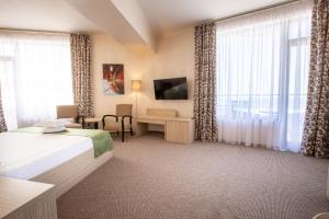 ママイアにあるHotel Buenoのベッド、デスク、窓が備わるホテルルームです。