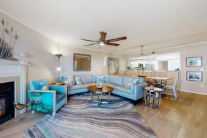 ein Wohnzimmer mit einem blauen Sofa und einem Tisch in der Unterkunft Beach Cottage 1311 in Clearwater Beach