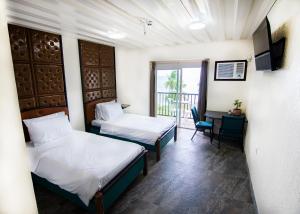 a hotel room with two beds and a balcony at Leuchtturm Resort in Boljoon