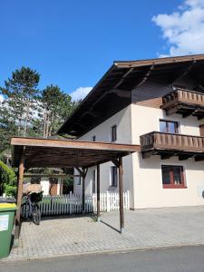 ein großes weißes Haus mit einem Holzdach in der Unterkunft The Steinbock Lodge with garden and bbq in Zell am See