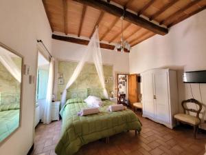 a bedroom with a green bed in a room at Residenza storica il Pozzo in San Quirico dʼOrcia