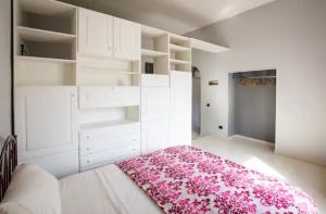 1 dormitorio con armarios blancos y alfombra rosa en Villa Giuseppina, en Meta