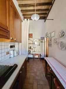 a kitchen with a counter and a table in it at Residenza storica il Pozzo in San Quirico dʼOrcia