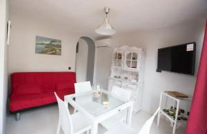 sala de estar con sofá rojo y mesa blanca en Villa Giuseppina, en Meta