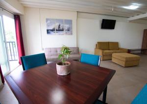 een conferentieruimte met een houten tafel en blauwe stoelen bij Leuchtturm Resort in Boljoon