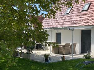 un patio con sillas y una sombrilla frente a una casa en Haus mit Garten Familie Pabst en Maria Lankowitz