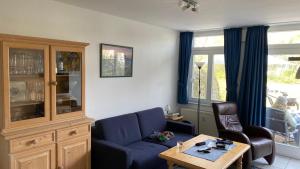 a living room with a blue couch and a table at Landhaus am Haff A9 in Stolpe auf Usedom
