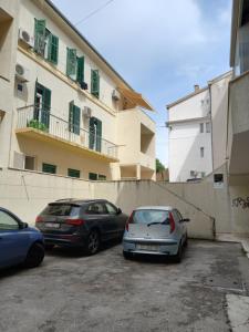 drei Autos auf einem Parkplatz vor einem Gebäude geparkt in der Unterkunft Apartman Diana in Split