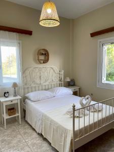 sypialnia z białym łóżkiem i żyrandolem w obiekcie Orange Country House w Chanii