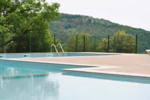 een leeg zwembad met een hek en water bij Le Domaine des Cazelles by Ateya Vacances in Cajarc