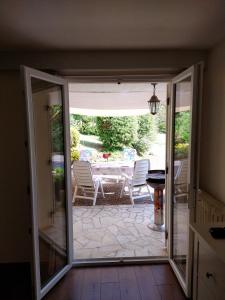 eine offene Tür zu einer Terrasse mit einem Tisch und Stühlen in der Unterkunft Gîte Chez Julie in Sarlat-la-Canéda