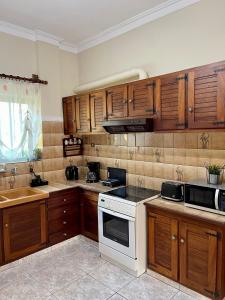 uma cozinha com armários de madeira e um forno de fogão branco em Orange Country House em Chania Town