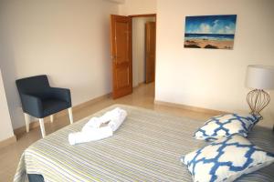 a bedroom with a bed with towels on it at Apartamento Deolinda - Nossa Sra da Rocha in Porches +9 photos