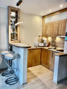 a kitchen with wooden cabinets and a counter top at SWEET APP AM SEE in Pönitz am See