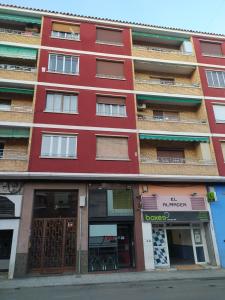 a red building with shops in front of it at El Refugio in Calatayud