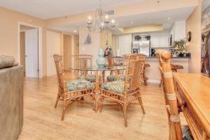 a dining room with a table and chairs and a kitchen at Beach Cottage 2202 in Clearwater Beach
