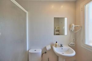 Nura Houses Duplex Magaluf 2 في ماغالوف: حمام مع حوض ومرحاض ومرآة