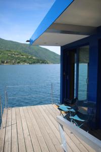 a dock with two chairs and a table on the water at Botel Diffuso dei Laghi in Porto Ceresio