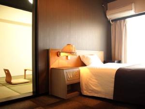 Postel nebo postele na pokoji v ubytování HOTEL LiVEMAX Osaka Namba