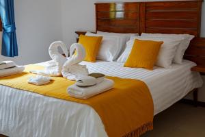 uma cama com toalhas e cisnes em cima em Le Be-Mahot - Hell Bourg em Salazie