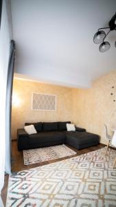 a living room with a black couch and a rug at Ballade Apartment in Iaşi