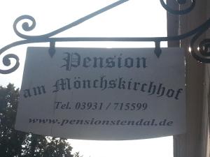 a sign on a pole that reads britonian am alhambraaten istg at Pension am Mönchskirchhof in Stendal