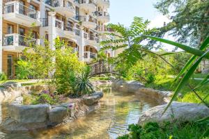 a hotel with a pond in front of a building at Harmony Suites - Dream Island in Sunny Beach