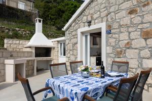 una mesa con un mantel azul y blanco en un patio en PERLA - small comfy house with the terrace, en Prožura