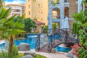 a metal bridge over a swimming pool in a resort at Harmony Suites - Dream Island in Sunny Beach