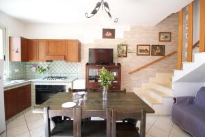 a kitchen with a dining room table and a living room at Villetta Rosetta by RENTHOUSESALENTO- a 100 m dal mare in San Foca