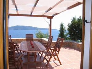 a table and chairs on a patio with a view of the water at Alonissos Luxury Villa with Jacuzzi and Beach in Agios Dimitrios