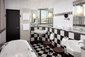 ein Bad mit schwarz-weiß kariertem Boden in der Unterkunft Hotel Victoria in Basel