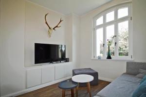 un soggiorno con un divano e una TV di 1899 - Das Ferienhaus a Wittmar
