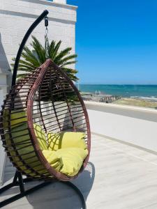 a hanging chair on a balcony with a view of the ocean at La Caletta Suite Torre Canne in Torre Canne