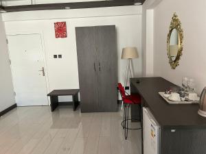 a kitchen with a counter and a door with a red chair at Tiana Boutique in Mağusa