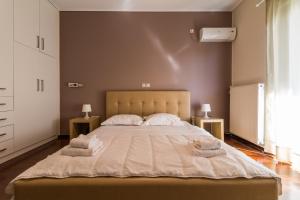 1 dormitorio con 1 cama grande y toallas. en Amazing Holiday Apt with Ocean Views, en Atenas