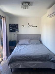 a bedroom with a bed with the word love on the wall at La Finca de Vane in Valle de Guadalupe